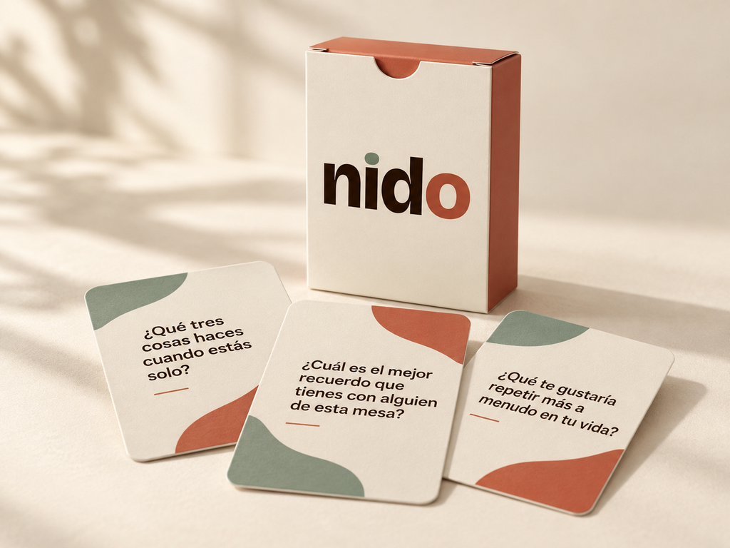 Caja del Juego de Cartas NIDO con tres cartas sobre la mesa